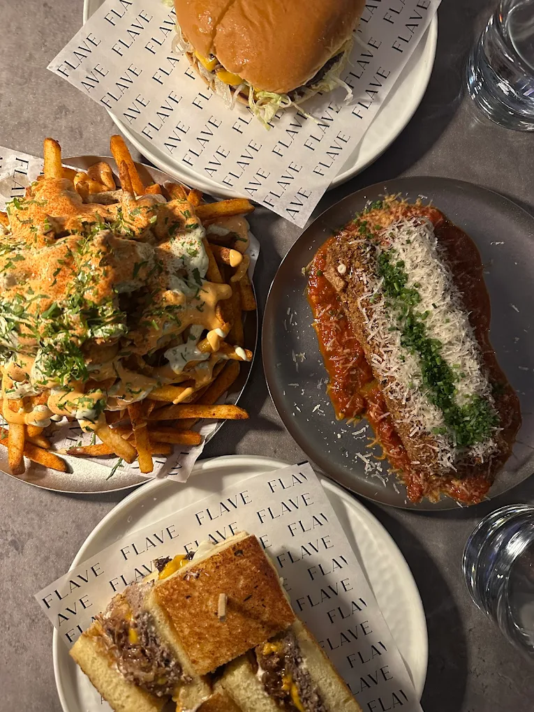 Table spread of burger, fries, parm chicken sub and sandwich
